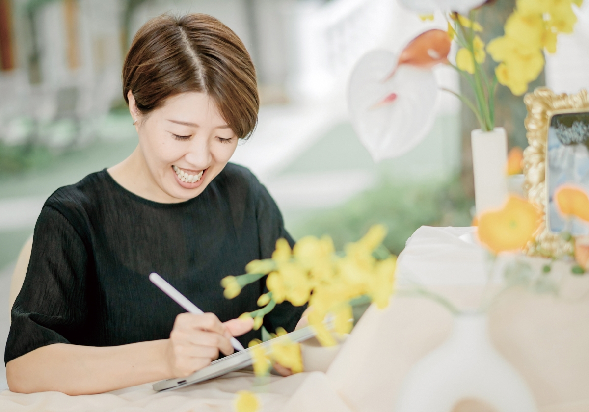 タブレットに絵を描いているブライダルデザイナーが笑顔で作業中