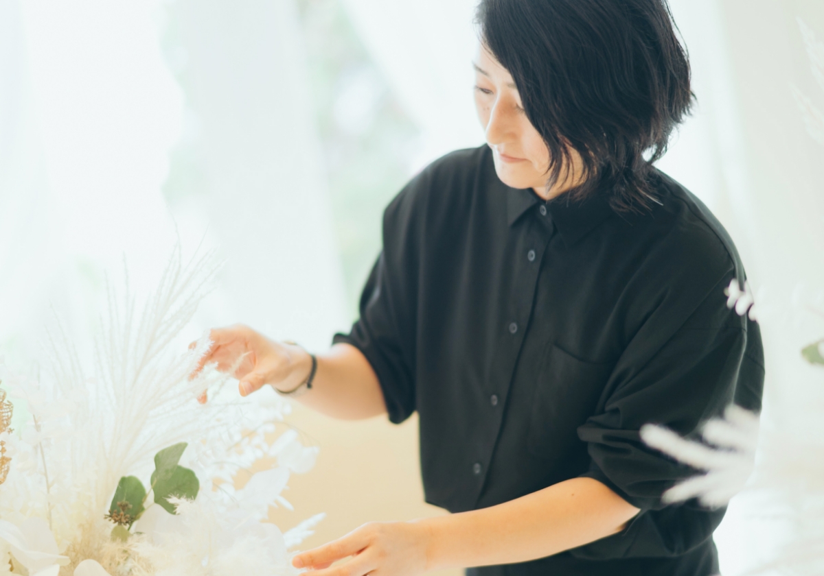 フローリストが白を基調とした装花を丁寧に手直ししている様子