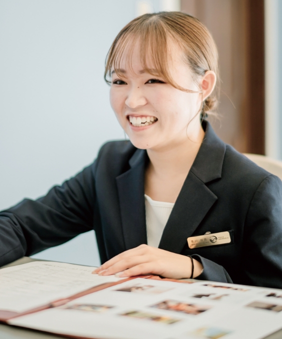 プランナーが資料を見ながら笑顔で応対している様子